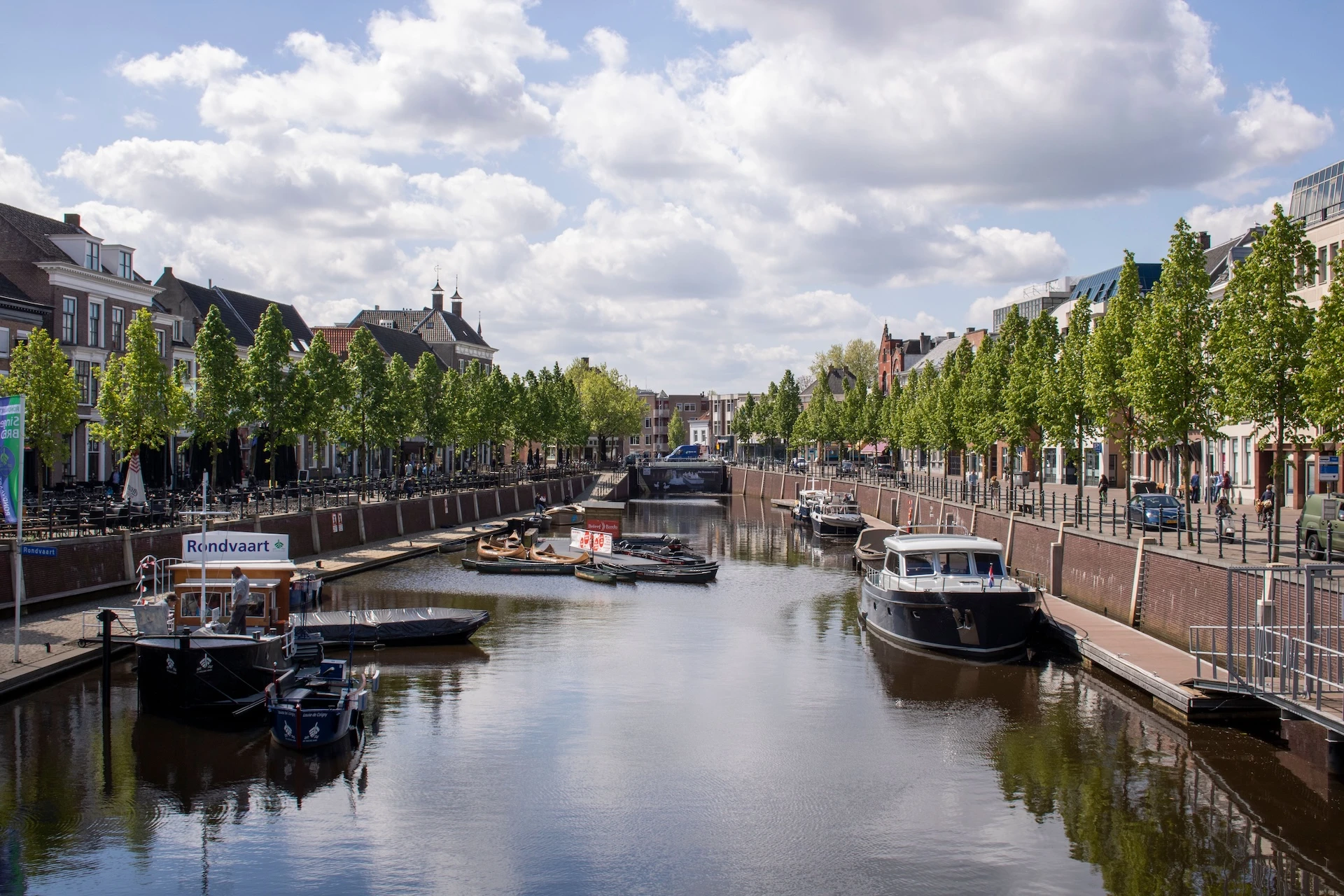 Gracht met bootjes en bomen in een Friese binnenstad