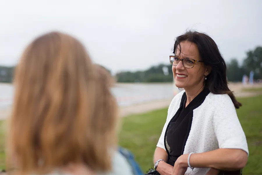 Vrouw in gesprek met iemand aan het water